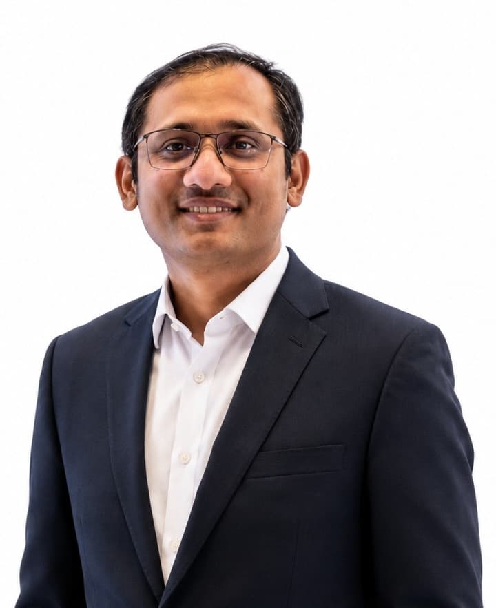 Professional portrait of Uachash Barua in a dark suit