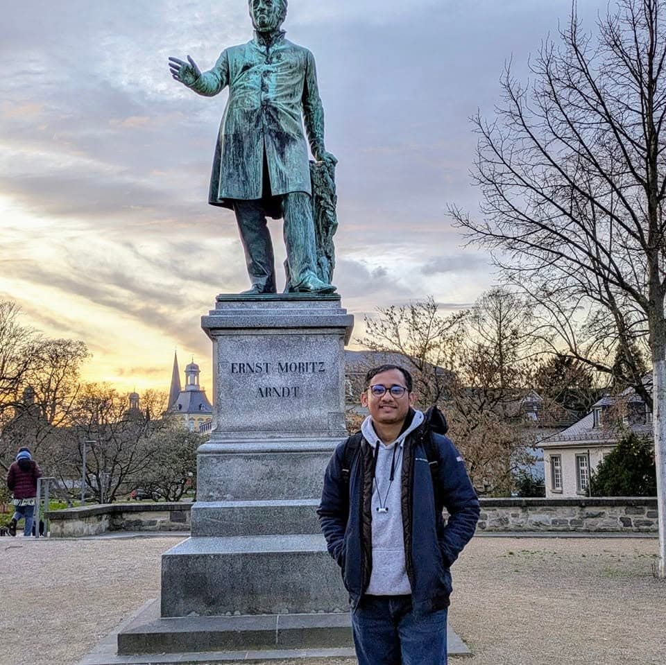 Uachash Barua standing beside the Ernst Moritz Arndt monument