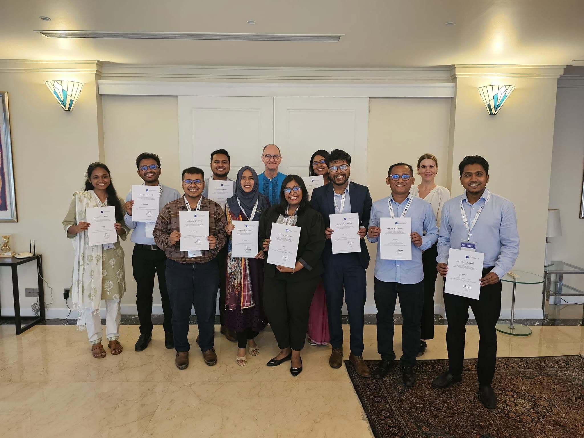 Group photograph of DAAD awardees holding Documents of Award